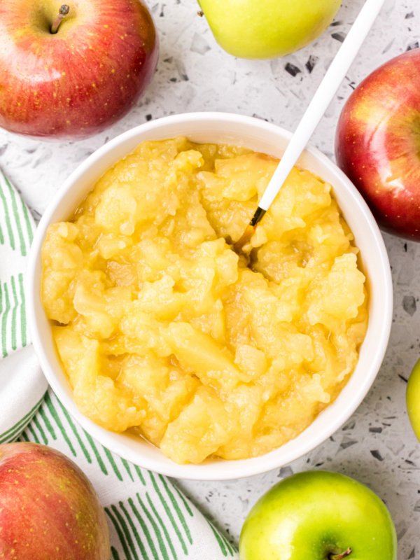 white bowl of applesauce with spoon