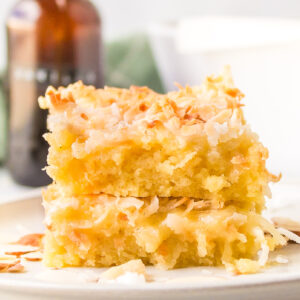 two almond coconut bars stacked on plate