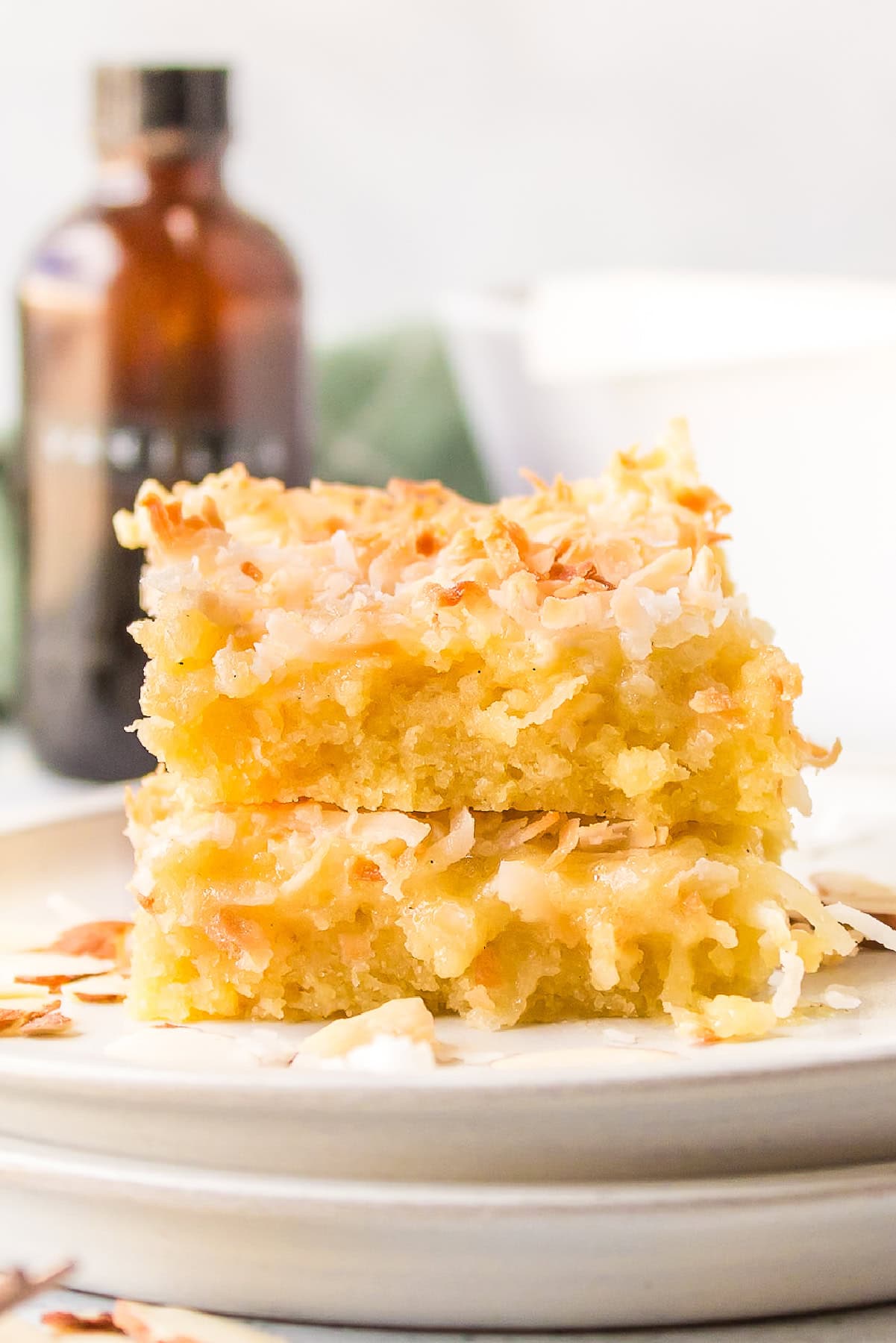 two almond coconut bars stacked on plate