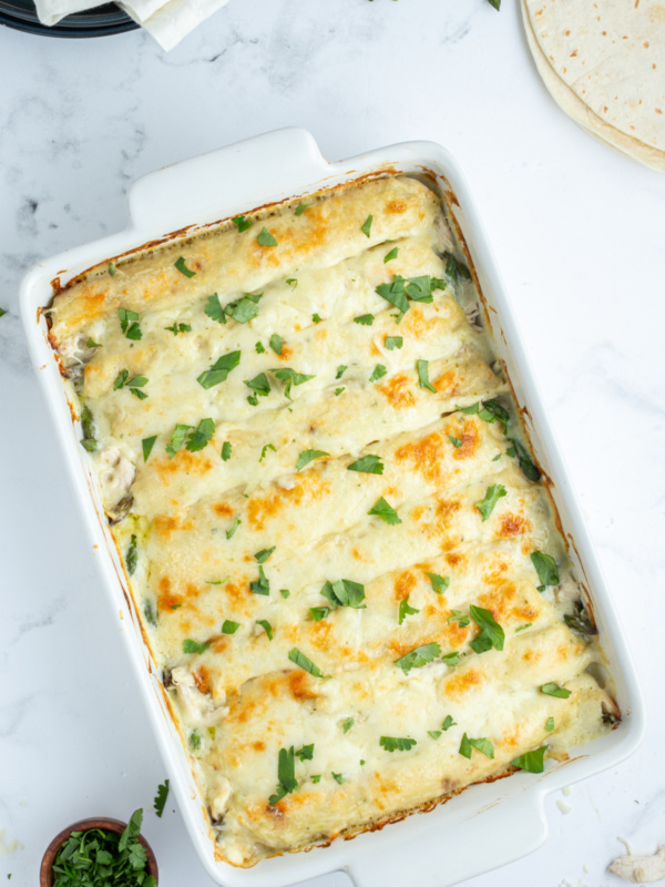 asparagus and chicken enchiladas in a baking pan