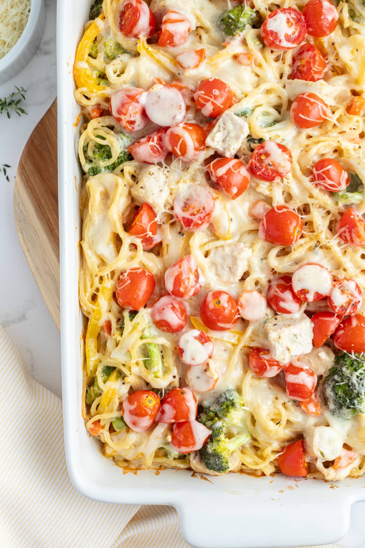 half view of baked lemon chicken spaghetti primavera in baking dish