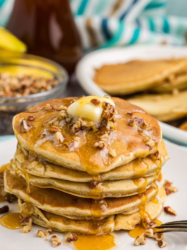 stack of banana pecan pancakes with butter and syrup