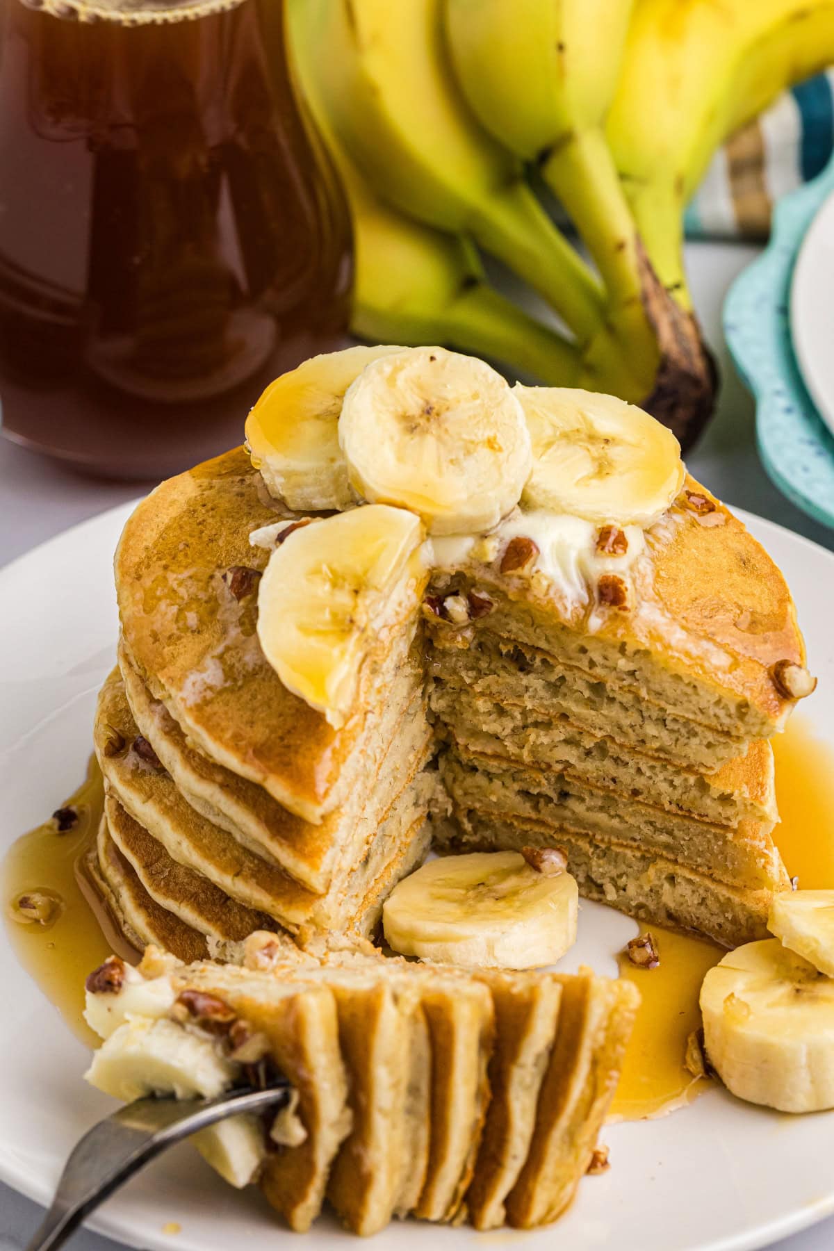 stack of banana pecan pancakes with big slice taken out of them