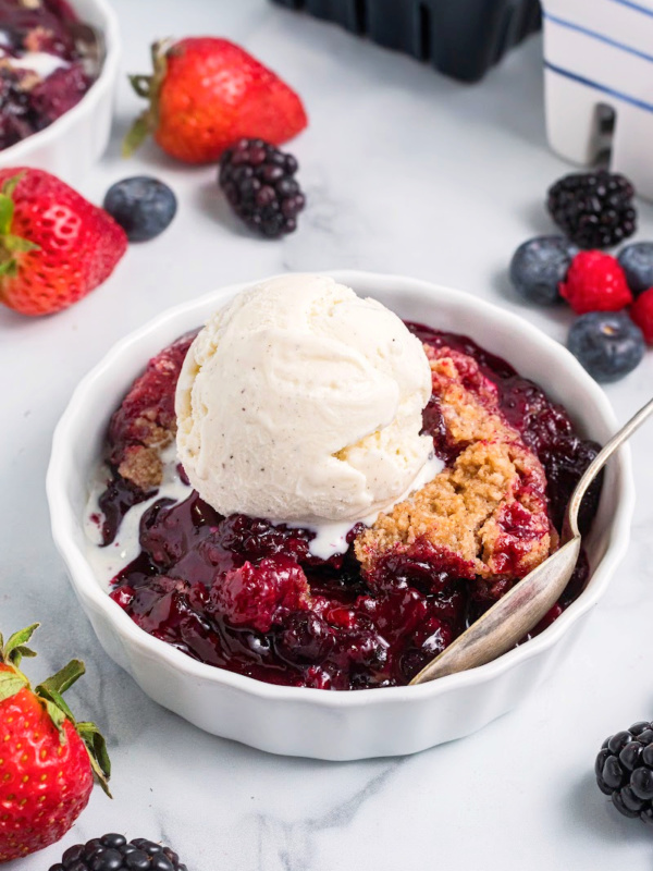 berry crumble in a dish with ice cream