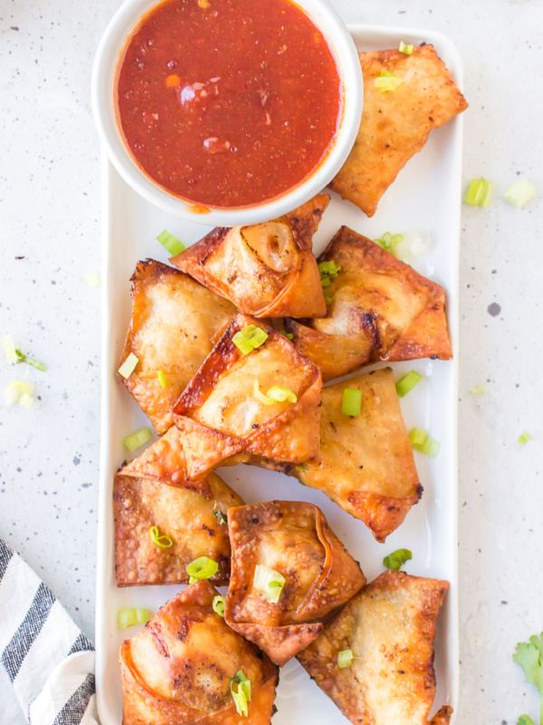 chicken and shrimp won tons on a white platter with bowl of dipping sauce