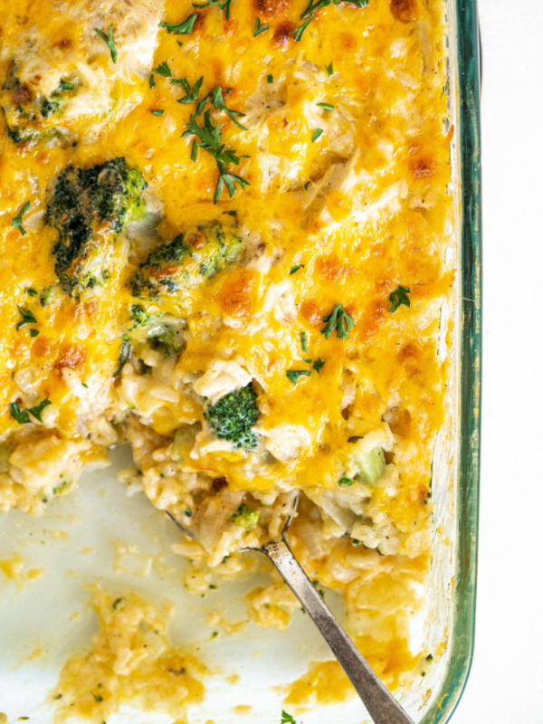 chicken broccoli and rice cheesy casserole in a casserole dish with serving taken out