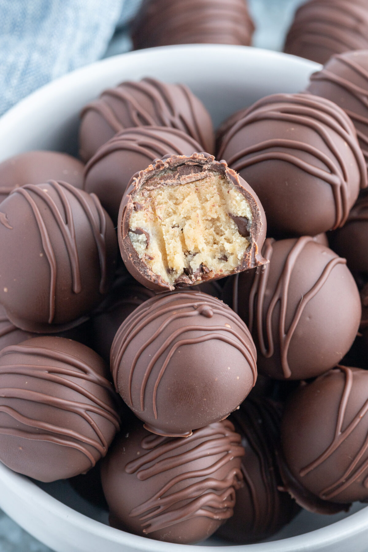 bowl of chocolate chip cookie dough truffles one with bite taken out of it