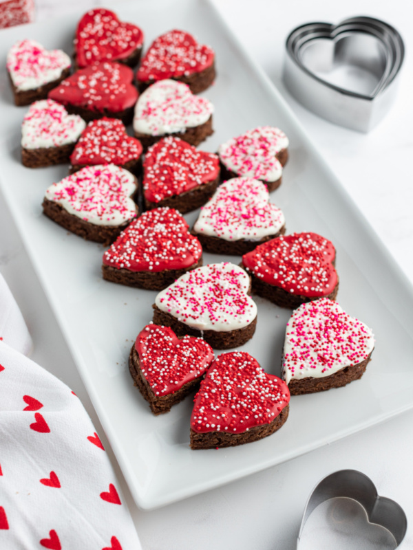 chocolate dipped brownies shaped as hearts on a white platter