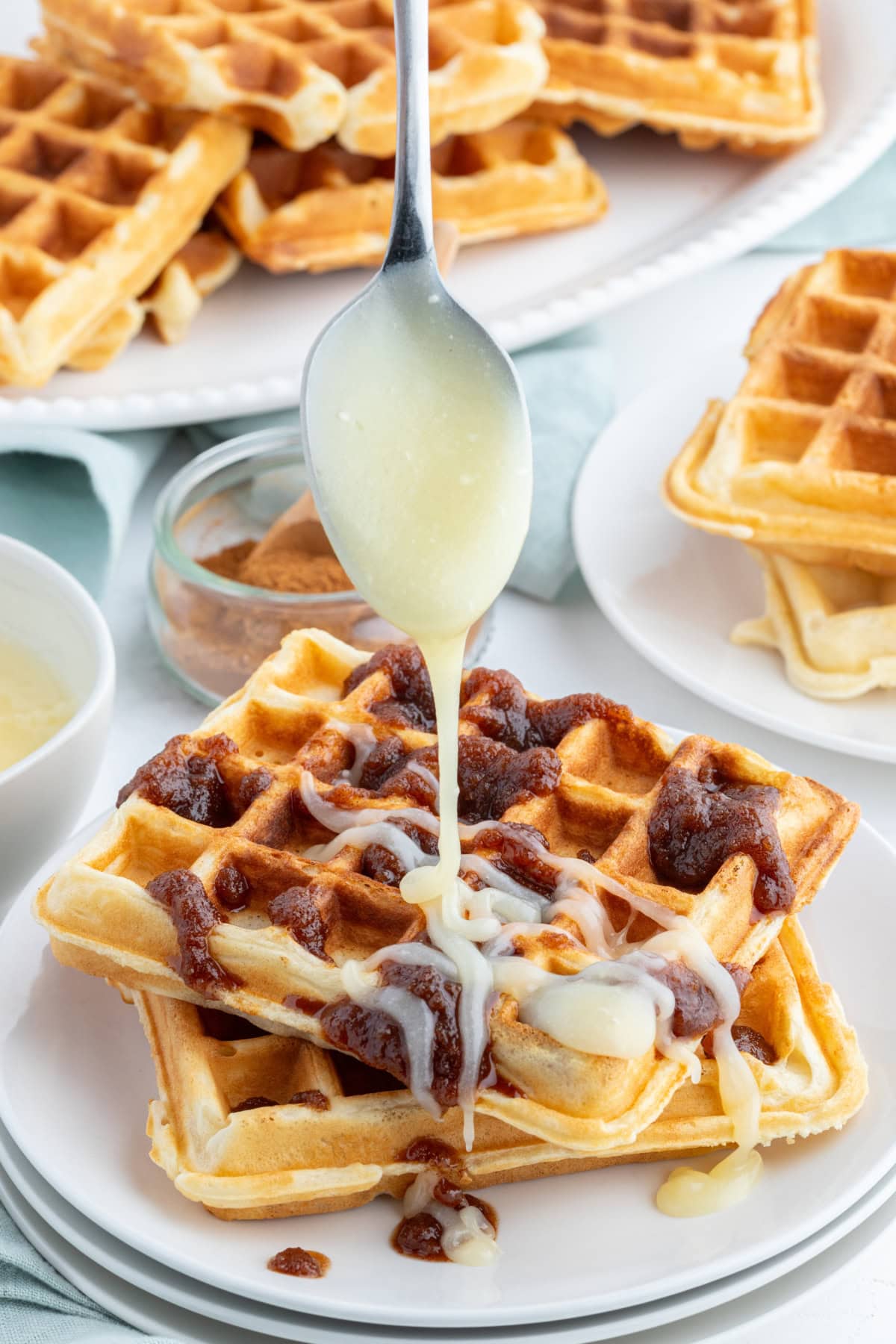 drizzling icing onto cinnamon roll waffle