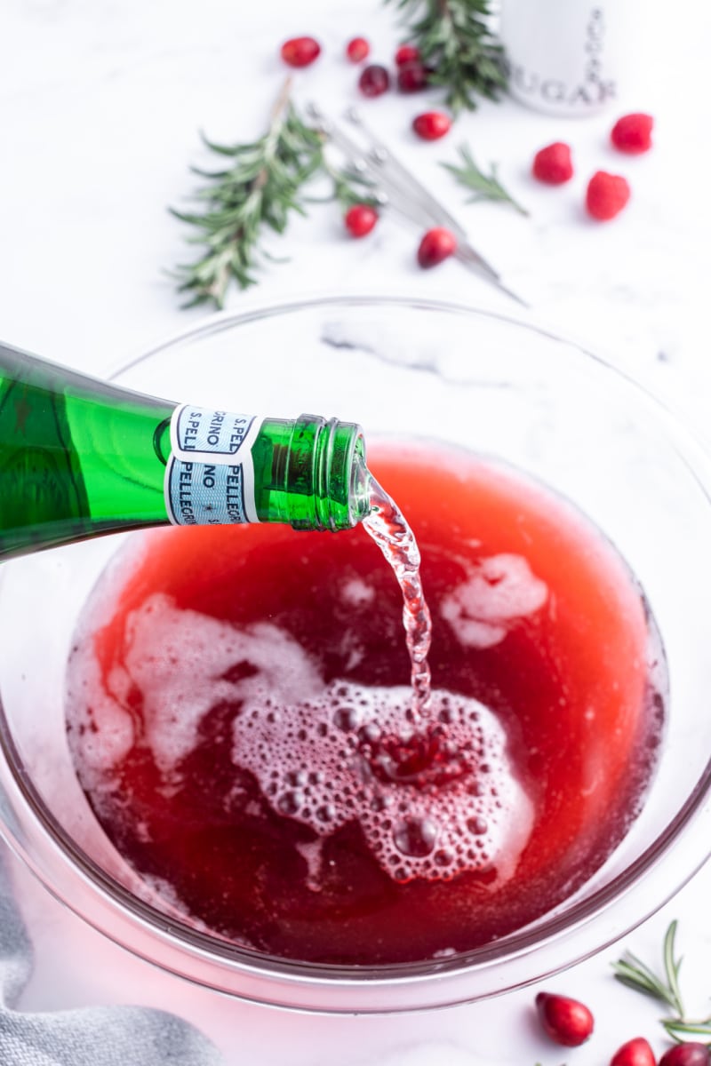 pouring sparkling water into cocktail