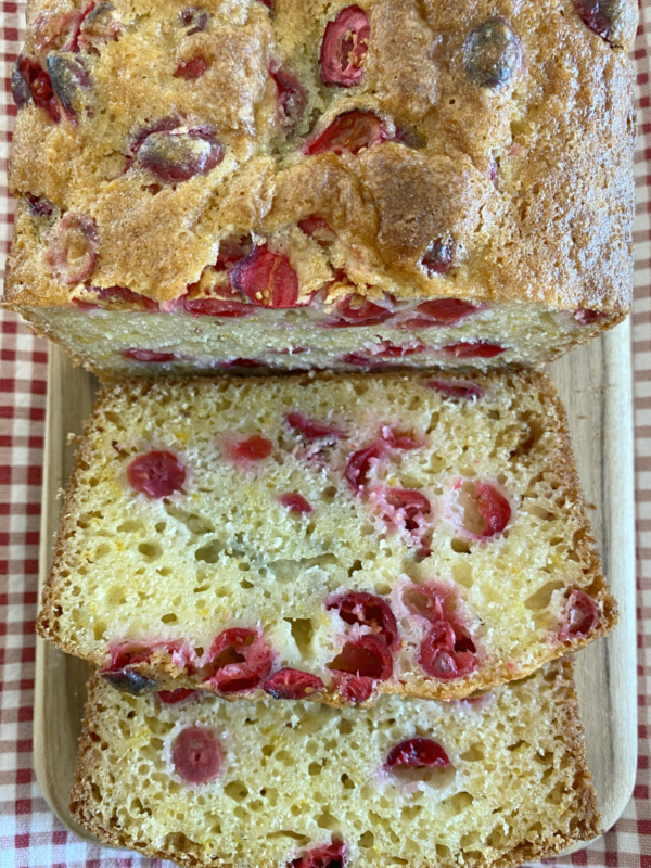 cranberry orange bread sliced on cutting board