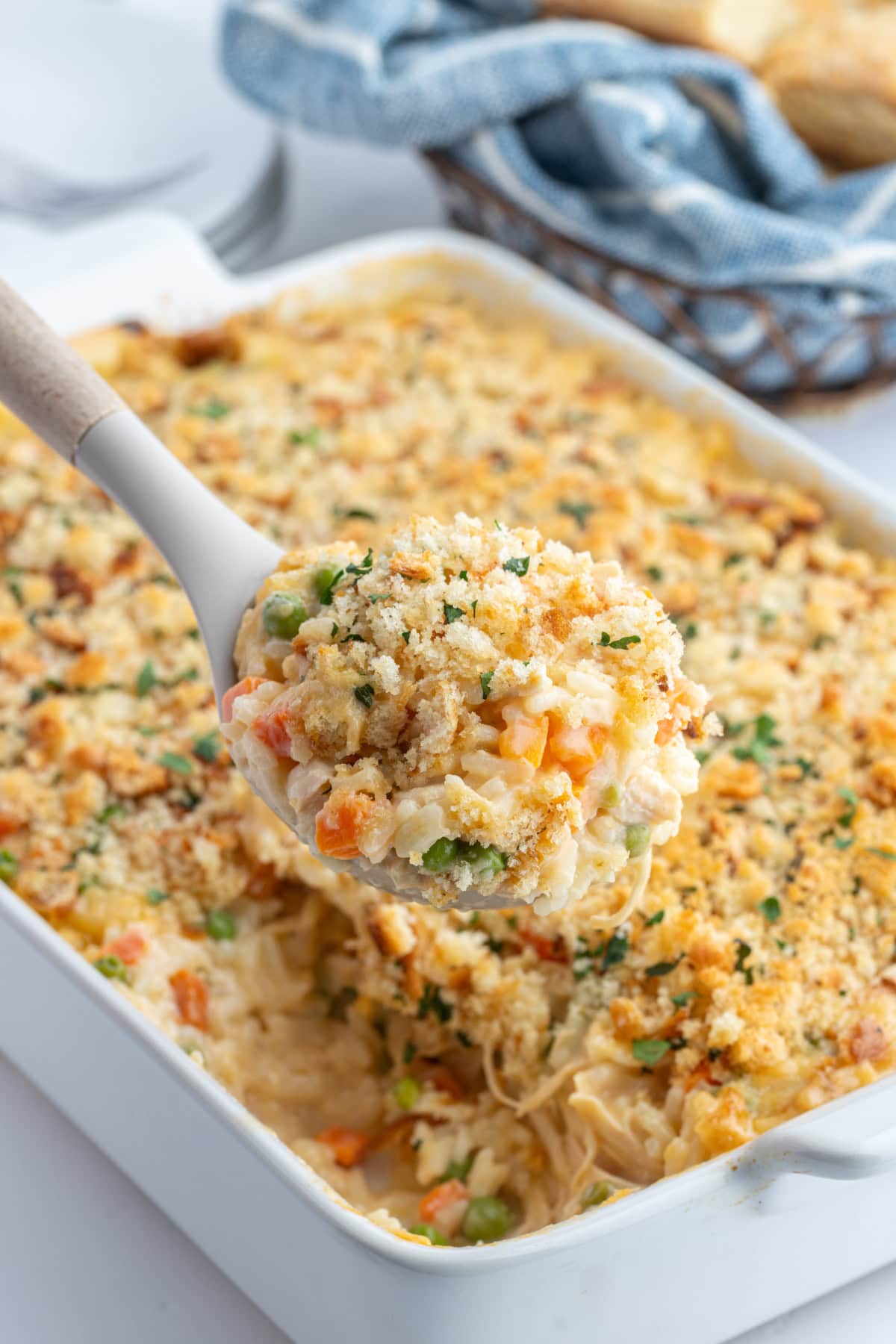 spooning out creamy chicken and rice casserole out of dish