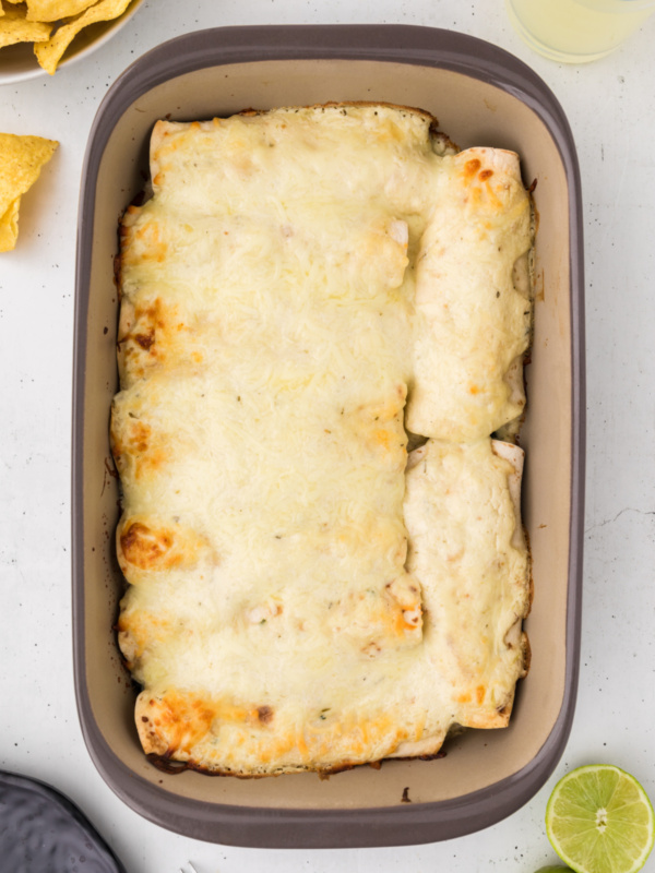 creamy chicken spinach and mushroom enchiladas in pan