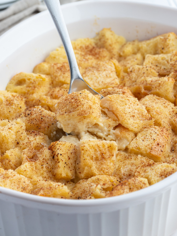 custard bread pudding in a baking dish with spoon