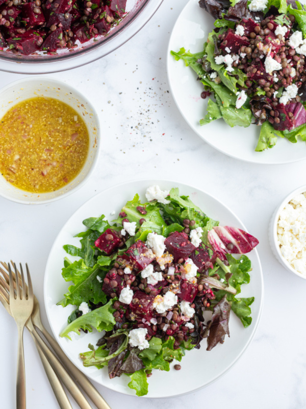 two plates of french lentil and roasted beet salad over greens