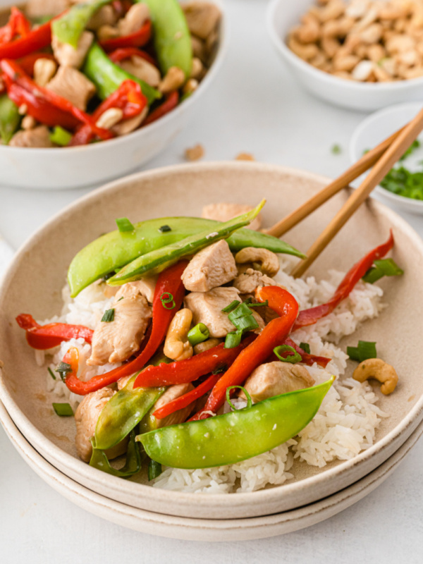 bowl of chicken stir fry with chopsticks