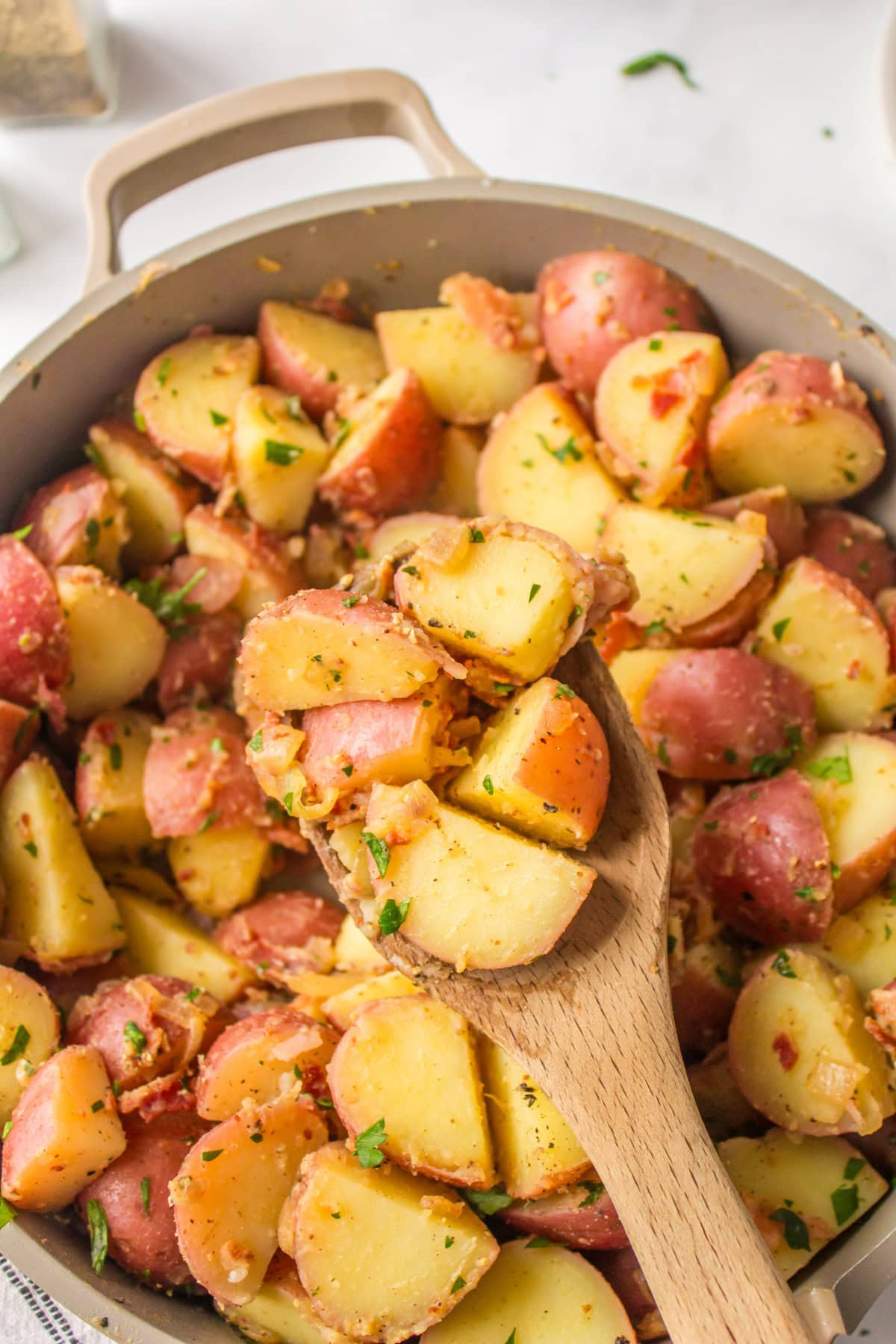 wooden spoon in pan of german potato salad