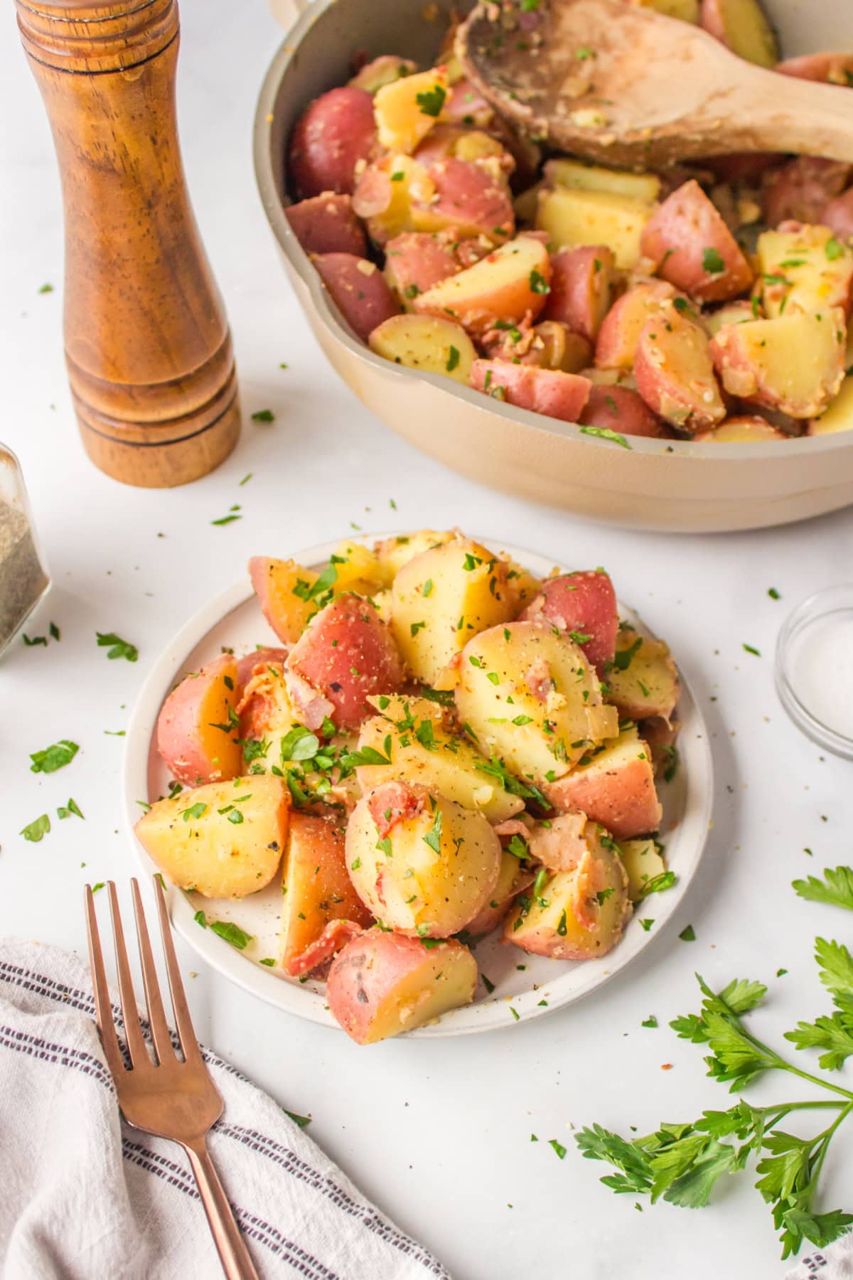 plate of german potato salad with whole salad in the background