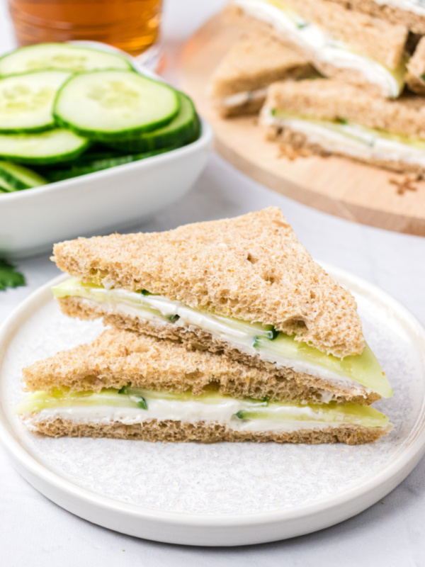 two goat cheese finger sandwich halves stacked on white plate