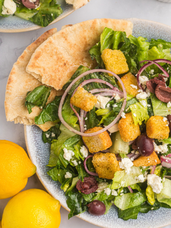 plate of greek caesar salad with pita bread