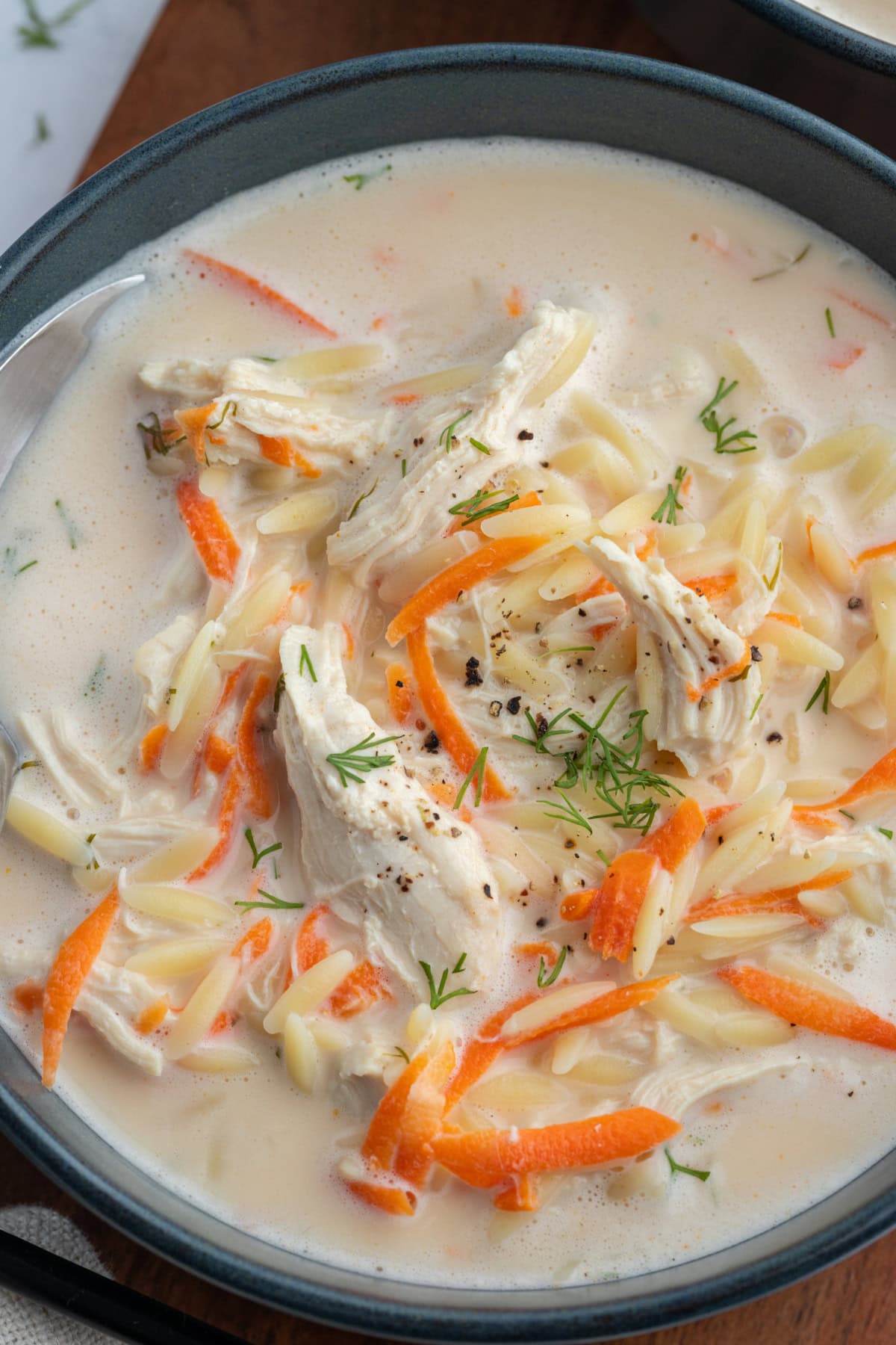 close up of greek orzo and chicken soup in bowl