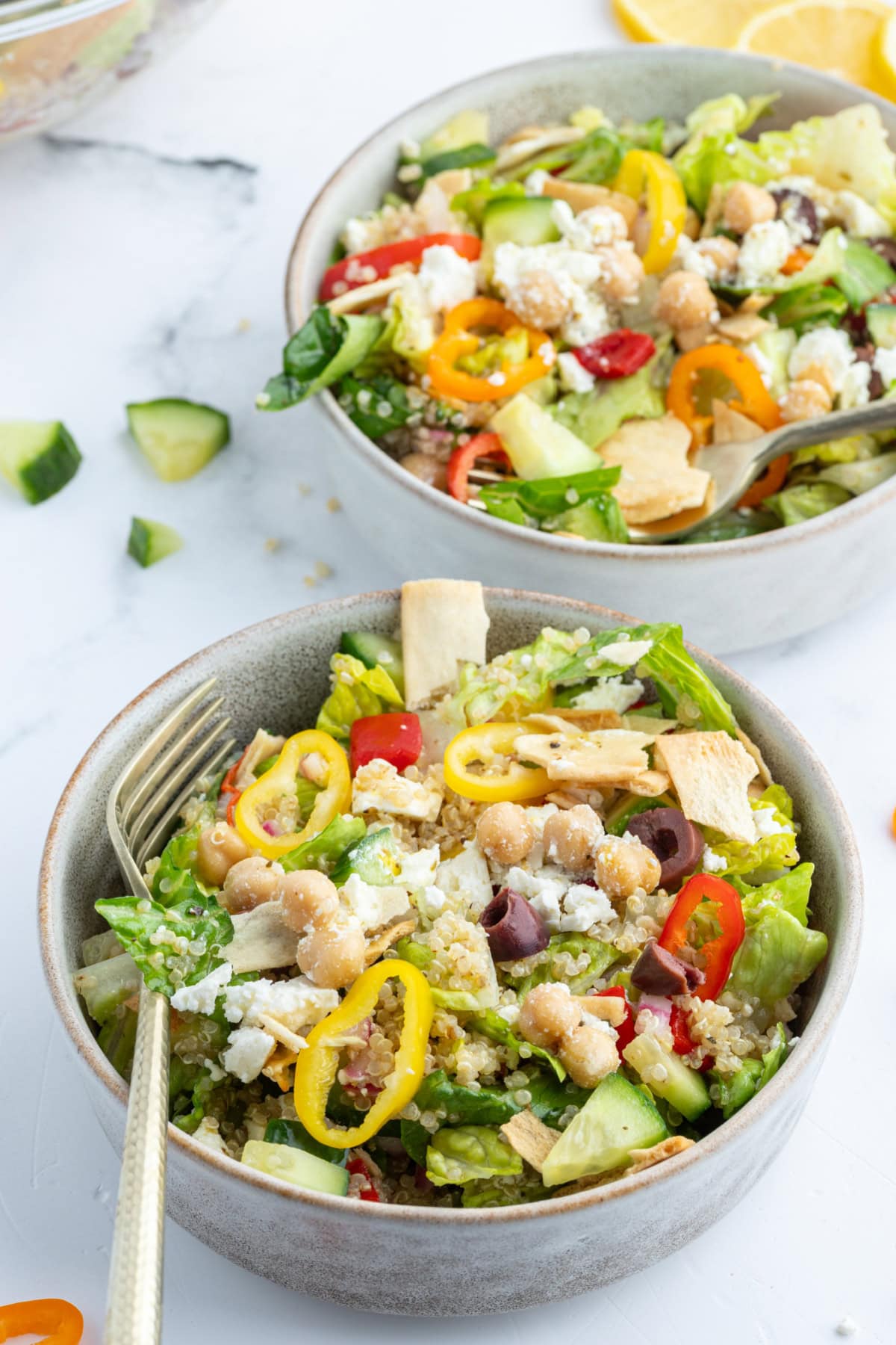 greek quinoa chopped salad in two bowls