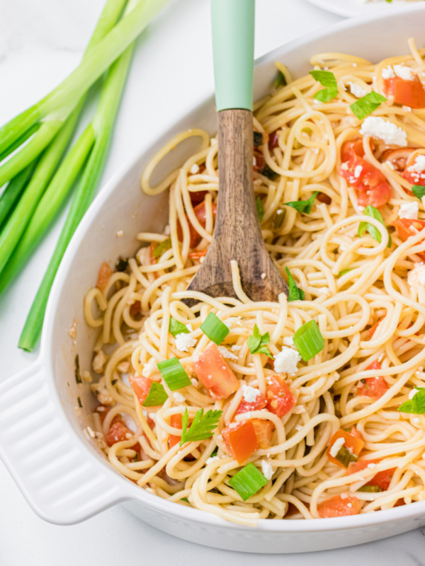 greek spaghetti in a serving dish with spoon