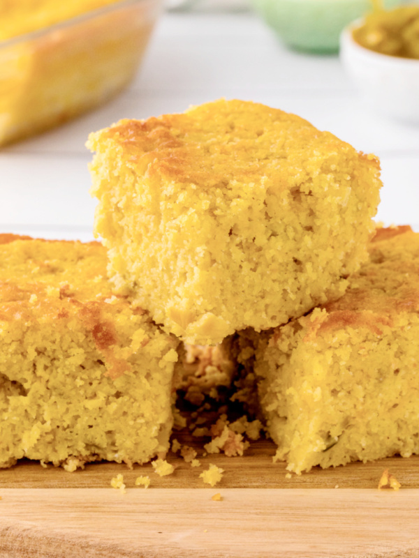 green chile cornbread pieces stacked on board