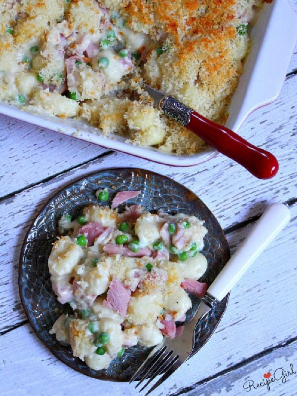 serving of ham and cheese gnocchi on plate with casserole dish too