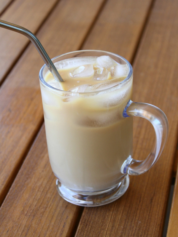 Cold Brew Coffee in a glass mug with a straw sitting on a wooden table