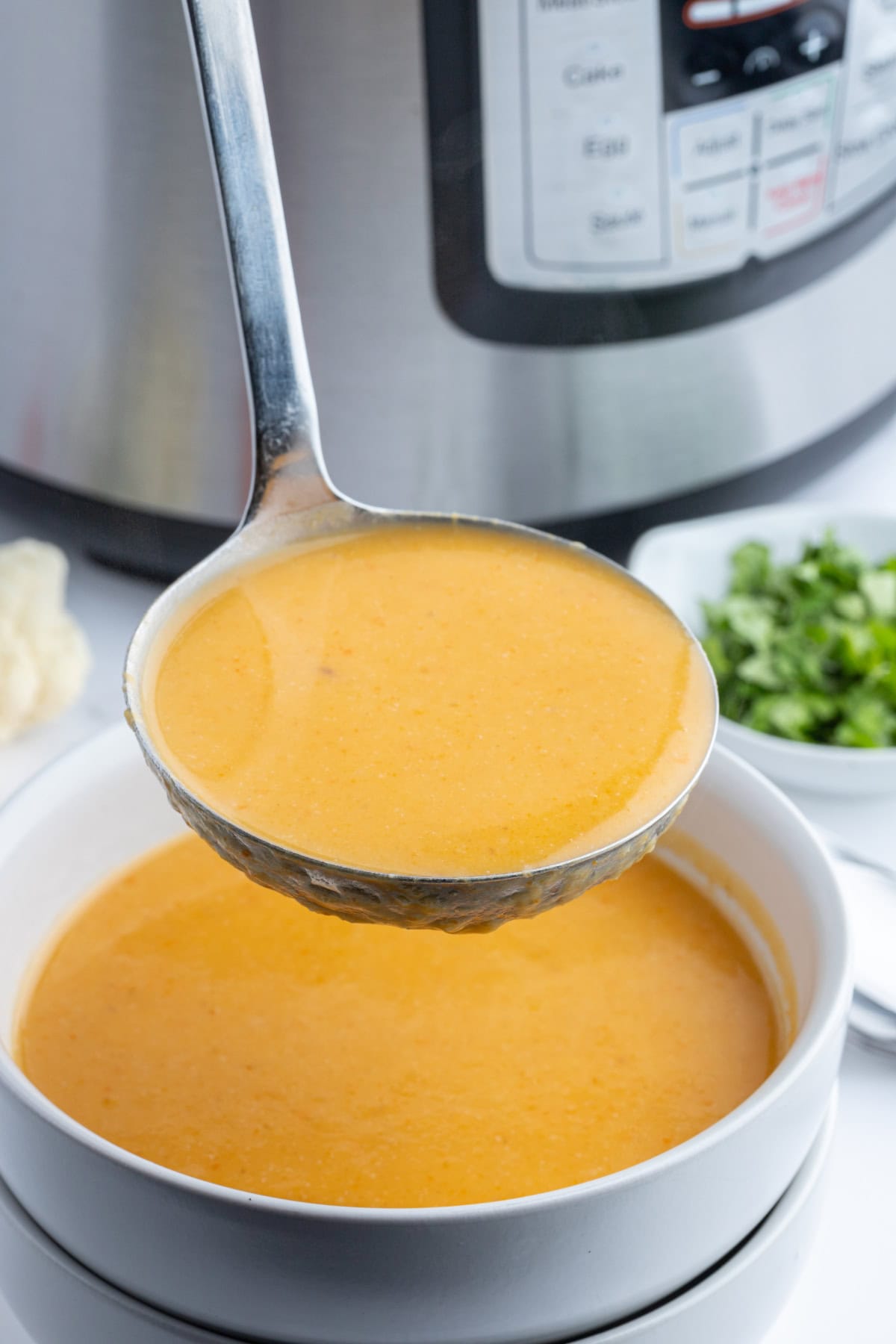 ladle full of cauliflower and sweet potato soup