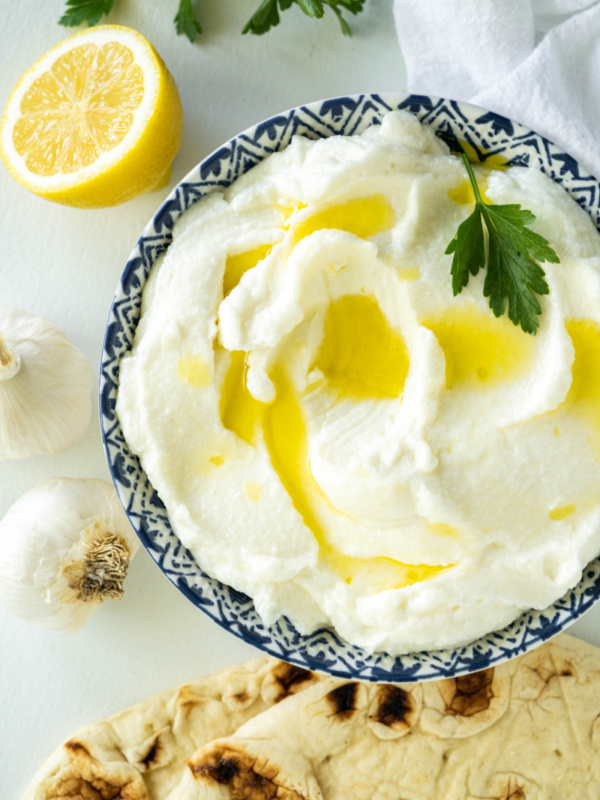 lebanese garlic dip in a bowl with pita on side