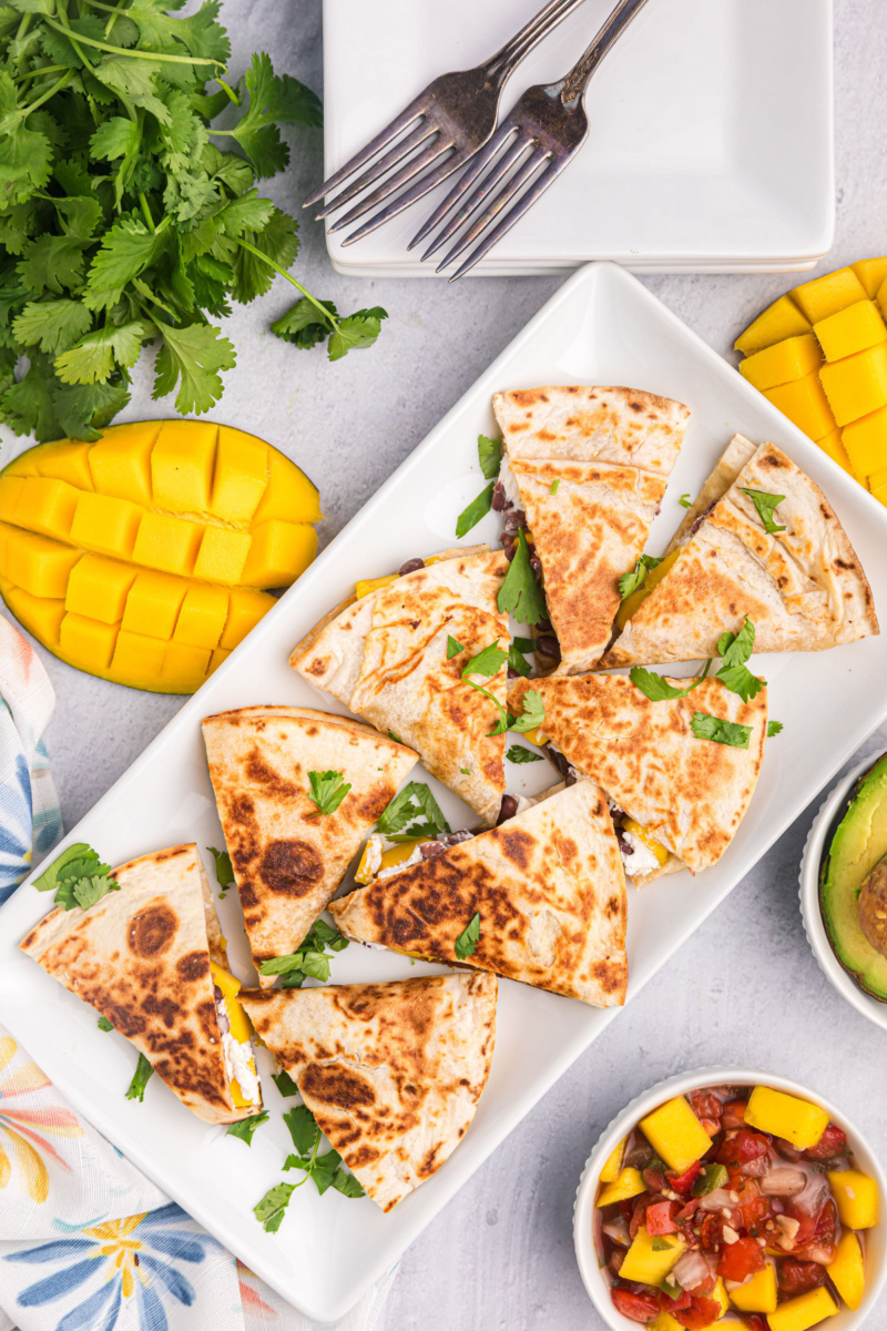 platter of pieces of mango black bean goat cheese quesadilla