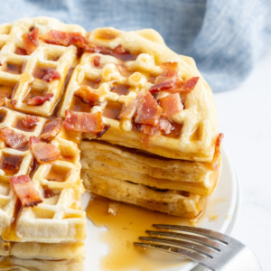 stack of maple bacon waffles with big slice taken out