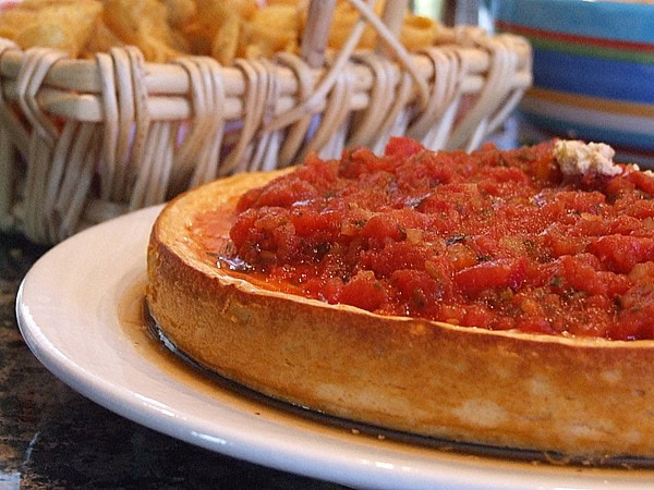 mexican cheesecake dip on a plate with basket of chips