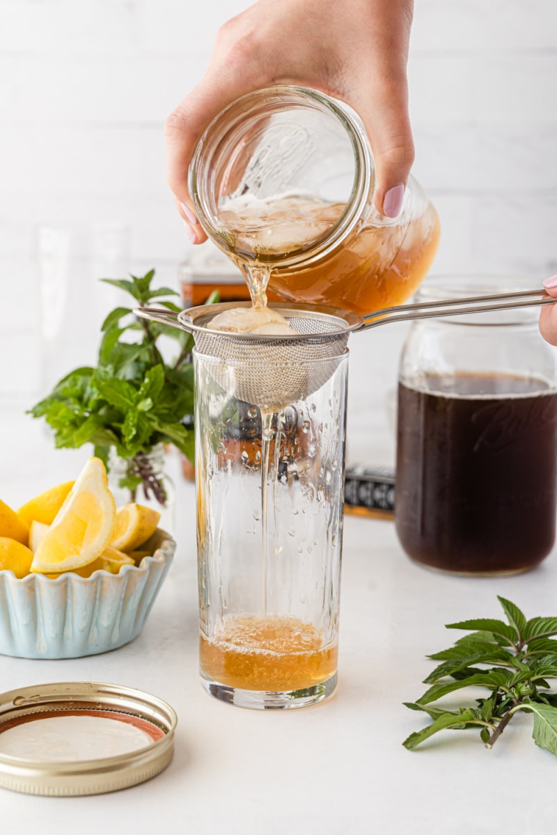 pouring millionaire's lemonade cocktail into glass