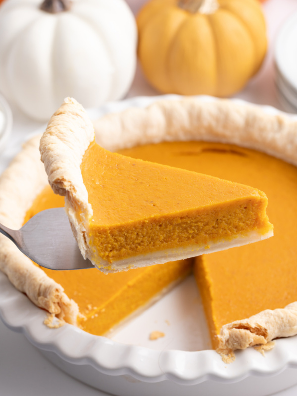 spatula taking slice of mom's pumpkin pie out of whole pie