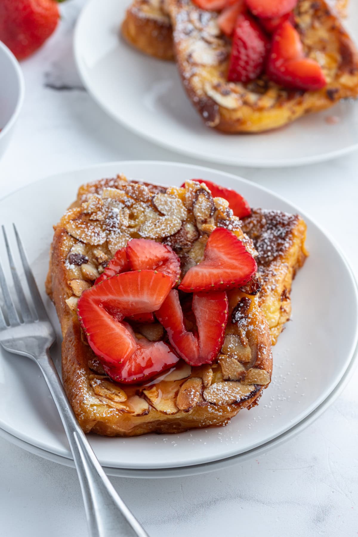 serving of pain perdu on plate topped with strawberries