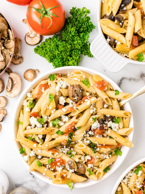 bowl of penne with mushrooms tomato and gorgonzola cheese