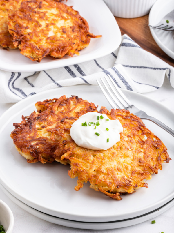 potato latkes on a plate with sour cream