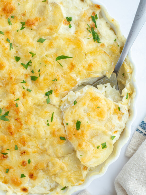 potato leek gratin in a casserole dish with a spoon