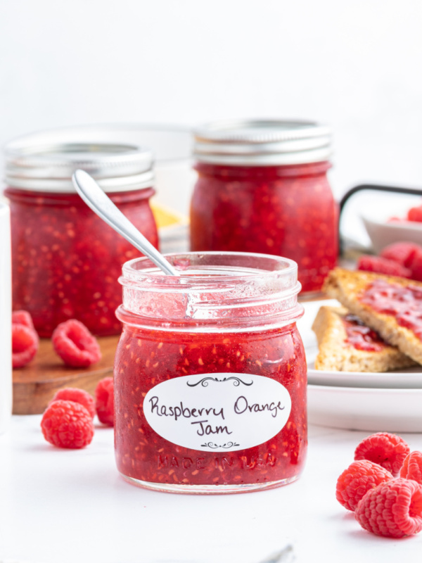 spoon inside jar of raspberry orange freezer jam