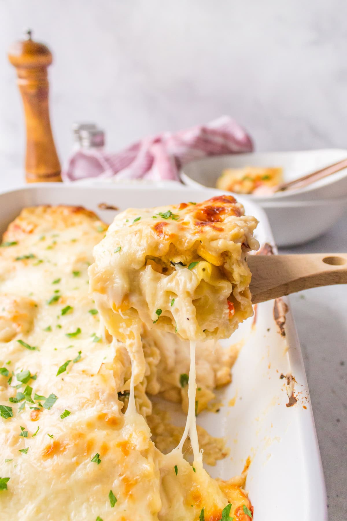 spatula taking toasted vegetable lasagna roll ups out of pan