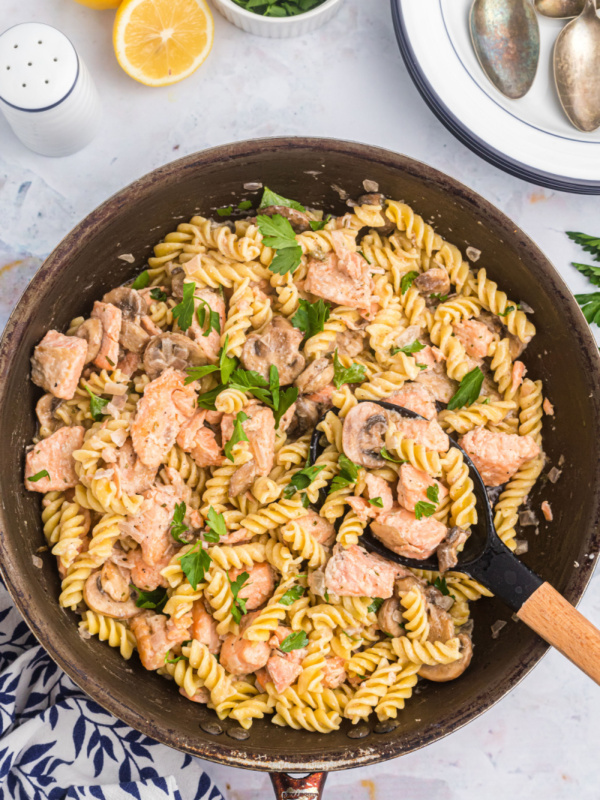 salmon fusilli in a skillet with spoon