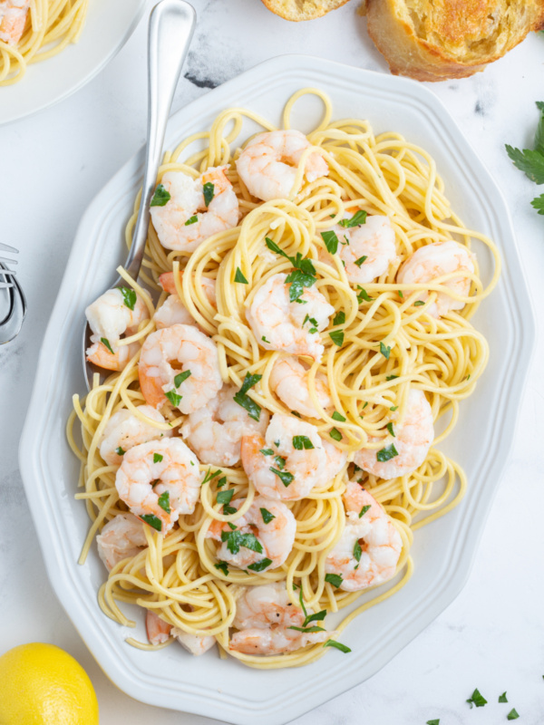 shrimp scampi on a platter over pasta