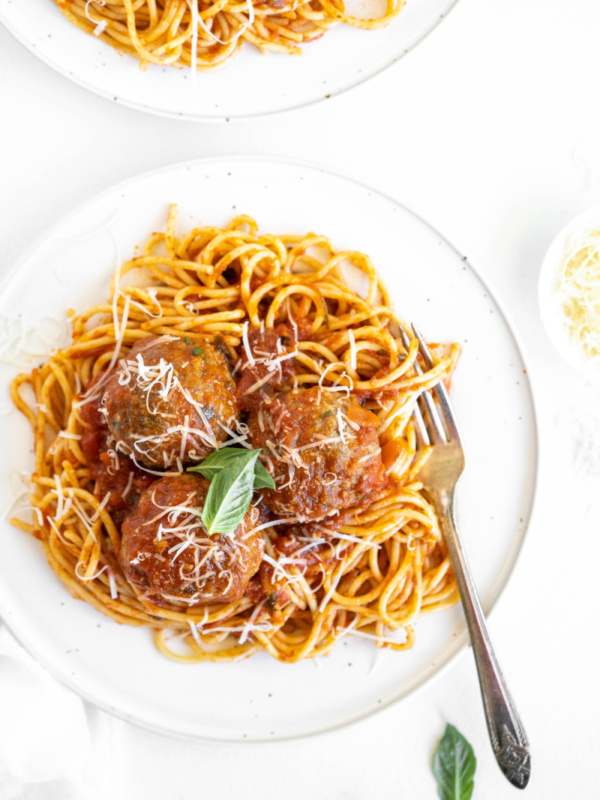 spaghetti and meatballs on a white plate