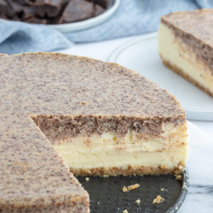 tiramisu cheesecake with large slice taken out of it