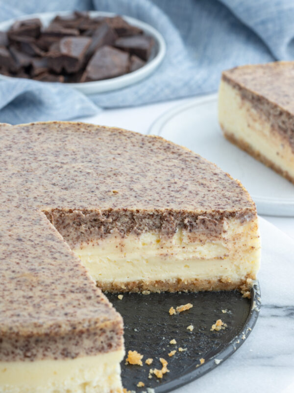 tiramisu cheesecake with large slice taken out of it