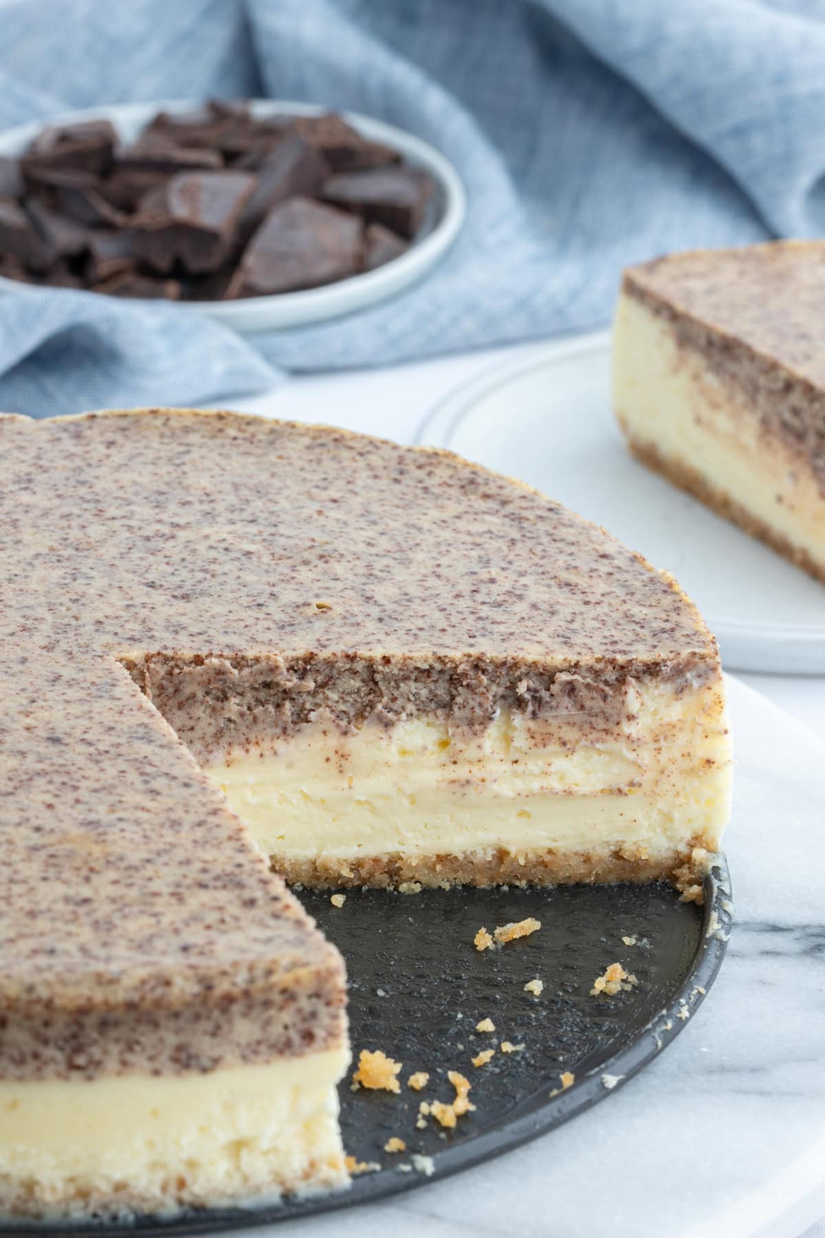 tiramisu cheesecake with large slice taken out of it