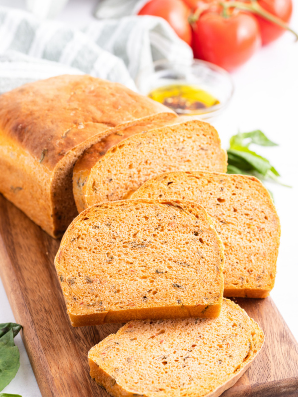 sliced tomato basil bread on a bread board